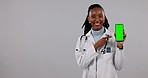 Black woman, doctor and phone green screen in advertising against a studio background. Portrait of African female person in medical or healthcare pointing to mobile smartphone app, display or mockup