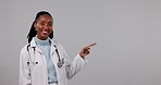 Black woman, doctor and pointing to mockup space in advertising against a studio background. Portrait of happy African female person, medical or healthcare worker showing notification or information