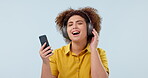 Phone, headphones and happy woman dance to music, listening to media and streaming audio online. Smartphone, radio and person moving to sound for freedom isolated on a blue background mockup space