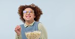 Woman, popcorn and funny movie with streaming and laughing in studio, entertainment and TV isolated on blue background. Eating corn snack, comedy film or show with happiness and online subscription