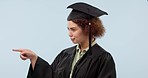 Graduation, pointing and woman in studio with decision, option and choice on blue background. University, college and portrait of student with gesture for education, certificate or qualification list