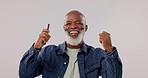 Face, phone call and black man with celebration, dance and achievement on a grey studio background. African person, senior model or winner with smartphone, success and wow with connection or giveaway