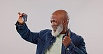 Selfie, passport and senior man smile in studio for travel, freedom or retirement adventure on grey background. Smartphone, profile picture and old male influencer smile with ID ticket for blog post 