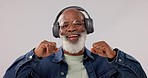 Senior, black man and dancing with headphones to music for audio streaming against a studio background. Mature African male person smile, enjoying or listening to sound, playlist or songs on headset