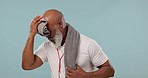 Senior, black man and sweating from fitness, exercise and workout with towel wipe in studio. Tired, athlete break and training of a coach with wellness and healthcare from sport with blue background