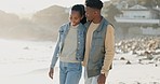 Black couple, walking and beach with love, bonding and care together by the sea with smile. Happy, freedom and vacation with young people relax with embrace by the ocean on adventure with travel