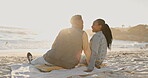 Smile, love and laughing with a black couple on the beach together at sunset for romance or dating from the back. Flare, ocean or summer vacation with a man and woman sitting on the sand by the sea