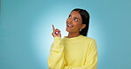 Happy, woman and thinking of idea and pointing hand to decision or solution in studio, mockup or blue background. University student, planning and presentation of problem solving, question or advice