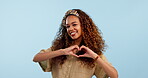 Face, heart and hands of happy woman in studio isolated on a blue background mockup space. Portrait, love sign and person smile with emoji for care, kindness gesture and support, romance or thank you