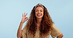 Perfect, wink and face of woman in studio with hand, sign and ok gesture on blue background. Happy, portrait and female model with finger emoji for thank you, motivation or vote, success or support