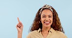 Mockup, pointing and face of happy woman in studio with empty space for marketing or advertising. Smile, excited and portrait of female model from Colombia with show hand gesture by white background.