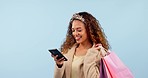 Happy woman, phone and shopping bag for discount, sale and retail giveaway or e commerce winner in studio. Excited customer or african person dance for mobile deal, gift or package on blue background