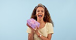 Excited, woman shake gift and box in studio isolated on a blue background mockup space. Portrait, happy person guessing present package and curious at party, birthday celebration and giveaway winner
