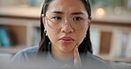 Face, computer and thinking with a business asian woman in her office for problem solving during project management. Glasses, idea and research with a young employee at work on a workplace desktop