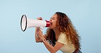 African woman, megaphone and protest, voice or power and broadcast or announcement on a blue background. Young person, student or leader with fist, call to action and attention or warning in studio