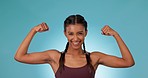 Strong, champion and woman flexing biceps for fitness, face and muscle with exercise isolated on blue background. Health, bodybuilder and happy athlete, portrait and workout in studio with training