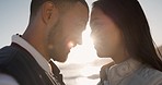 Forehead, beach and couple with love, marriage and lens flare with commitment, trust and smile. Romance, man and woman with vacation, seaside holiday and relationship with happiness, care and bonding