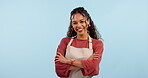 Barista, cafe employee and woman with arms crossed, face and smile, waitress in studio on blue background. Professional, confidence and happy in portrait, small business and entrepreneur with owner