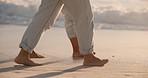 Travel, sunset and beach and feet of couple walking for health, freedom and love. Romance, relationship and peace with closeup of man and woman on seaside date for summer, legs and relax together