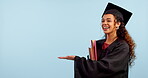 Graduate, woman and student pointing to space in education, college or university presentation in studio. Face of african person of graduation information, palm and learning offer on blue background