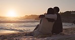 Couple, sunset and beach with love, hug and travel by the ocean by water sitting on sand. Vacation, island and date by the sea of young people back together with summer peace and relax outdoor