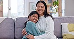 Hug, face and mother with girl child on a sofa with trust, care and happy in their home together. Portrait, love and mom embrace kid in a living room relax, chilling and smile with bonding in a house