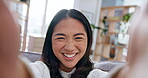 Selfie, smile and a happy asian woman closeup on a sofa in the living room of her apartment to record a video. Portrait, face and smile of a confident influencer filming a home movie for social media