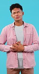 Stomachache, pain or indigestion and a man on a blue background in studio with abdominal nausea. Healthcare, medical or belly problems and a young person on a vertical backdrop with tummy cramps