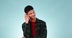 Thinking, brainstorming and young man in a studio with dreaming, guess or question facial expression. Remember, reflection and model from Mexico with curious, solution or idea face by blue background