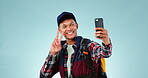 Social media, studio or student vlogging with smile, peace sign or scholarship on blue background. Bag, university or happy man excited to show school education, college or campus on online selfie