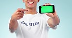 Phone, green screen and closeup of man in studio pointing to mockup space for marketing. Tracking markers, chroma key and male volunteer with show hand gesture to cellphone mock up by blue background