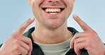 Smile, dental health and a person pointing to mouth for cleaning, Invisalign or braces on a blue background. Medical, healthcare and hands to show results or progress or teeth whitening and hygiene