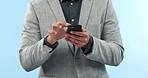 Phone, hands and closeup of businessman in studio typing a message on social media or mobile app. Technology, proud and professional male lawyer scroll on internet with cellphone by blue background.