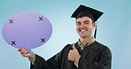 Graduation, man and speech bubble in studio, face and smile for thumbs up, quote or mockup by blue background. College student, poster and space for tracking markers, portrait and education promotion