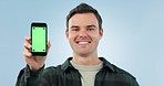Green screen, phone and face of man in studio with social media, news or sign up promo on blue background. Smartphone, display and portrait of male model with space for branding, contact or platform