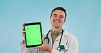 Doctor, healthcare and tablet green screen for clinic presentation and advice on blue background. Face of medical man or worker speaking on digital mockup, telehealth and tracking marker in studio