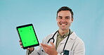 Doctor, speaking and tablet green screen for healthcare presentation and advice on blue background. Face of medical man or worker with digital mockup, website information or tracking marker in studio