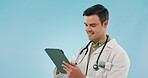 Happy, doctor and man with research on tablet on blue background or mockup space with online communication or report. Reading, typing and man in healthcare with telehealth, tech and scroll on app