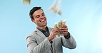 Money rain, business man and cash in studio with financial freedom, winner prize or reward. Professional person celebrate on blue background with lottery bonus, investment cashback and profit shower