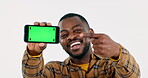 Happy black man, pointing or phone green screen for social media advertising or online branding. White background, show or face of person with smile, mobile app chroma key or mockup space in studio