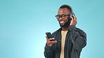 Black man, headphones and dancing studio with music, radio or audio with happiness on blue background. Listen, smile and person with digital media streaming hip hop, sound or podcast for freedom