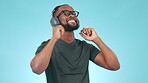 Music, headphones and happy black man dance in studio, streaming audio and hearing sound. African person listening to radio, smile and moving with energy in celebration isolated on a blue background