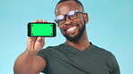 Phone, green screen and tracking markers on screen with a black man in studio on a blue background. Homepage, website and chromakey on a mobile display for marketing, advertising or internet app