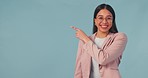 Face, smile and business woman with hand pointing in studio for presentation on blue background. Portrait, happy and female entrepreneur show checklist, vote or deal, promotion or we are hiring offer