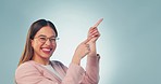 Face, business and woman with promotion, pointing and announcement on a blue studio background. Portrait, person and model with hand gesture, employee and opportunity with decision, worker and choice