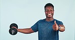 Fitness, man and dumbbell with thumbs up for training, exercise or workout in studio on blue background. Weightlifting, person and personal trainer for wellness and healthy body with smile at gym