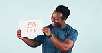 Happy man, discount and holding poster in studio background with mockup, advertising and promotion. African man, smile and announcement of sale in retail shopping deal and price information on offer
