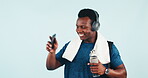 Man, cellphone and dancing in studio with headphones, towel and bottled water for gym or workout. African athlete, mockup and technology with sportswear, active lifestyle and smile for music to train