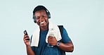 Black man, fitness and phone dancing to music for sports motivation against a studio background. Happy African male person smile with headphones listening to sound track or enjoying audio streaming