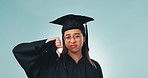 Thumbs down, graduation and debt with a woman in studio on a blue background for education. Portrait, scholarship and student loans with an unhappy university or college graduate looking upset